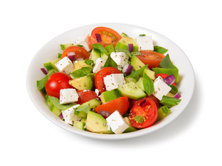 Salad with tomato, avocado, cucumber and  feta cheese in a white bowl isolated on white background.