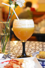 Cocktail, a vase with flowers, and sweets. 