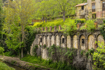 Fototapeta na wymiar A green background with houses and archs at river Darro shore in Granada, Spain
