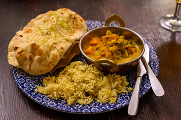 Mangalorean style roasted cauliflower and spinach curry with basmati rice and garlic naan bread, tasty vegetarian food