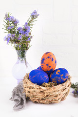 A nest with easter eggs and rosemary close up on a white background