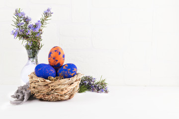 A nest with easter eggs and rosemary close up on a white background
