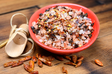 Pink himalayan salt chrystals with dried seeds of red hot chili peppers and herbs