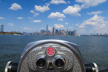 Close up of binoculars telescope with an amazing bokeh view over the Hudson river and manhattan skyline