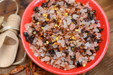 Pink himalayan salt chrystals with dried seeds of red hot chili peppers and herbs