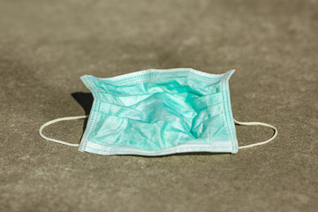 Used protective mask lies on the street