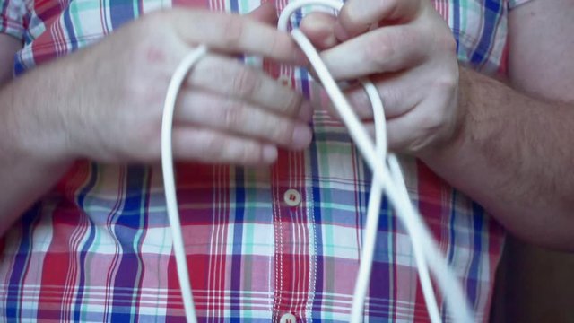 men's hands unravel electrical wires.