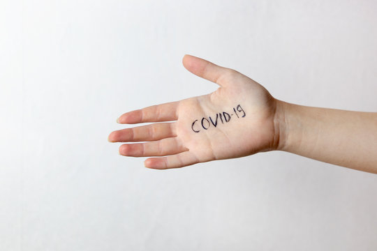 Hand with covid-19 written on palm. Dangerous touch concept, prevent spread of virus, no handshake