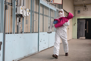 A man in a protective suit evacuates people
