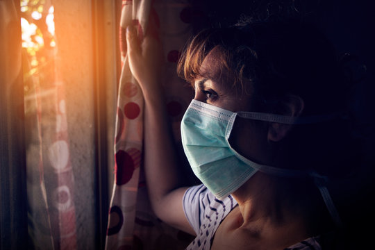 Mujer mirando desde el interior de su casa. No puede salir por el coronavirus