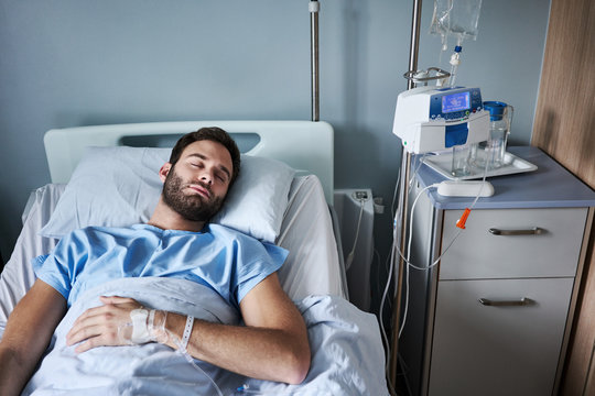 Young man on an intravenous drip sleeping in a hospital