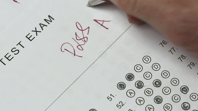 teacher writing a plus on multiple choice test