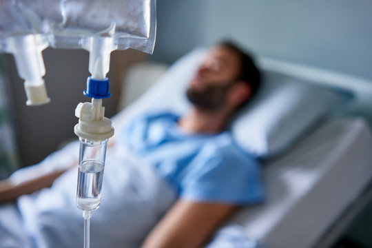 Sick man attached to an intravenous drip in a hospital
