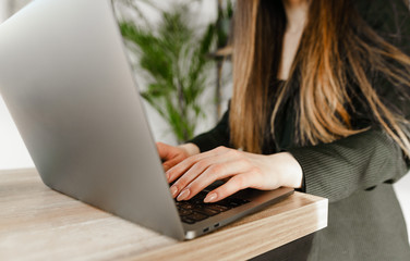 Hands of businesswoman typing text on laptop keyboard in cafe, closeup photo. Background. Working on a laptop. Girl in formal wear uses a laptop. Office worker working on laptop. Copy space