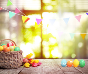 Bright Easter eggs and tulips on table indoors