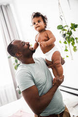 Loving father holding cute newborn daughter and smiling