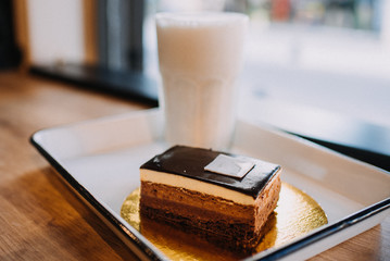licuado de banana con torta 3 chocolates en cafeteria con ventana a la calle