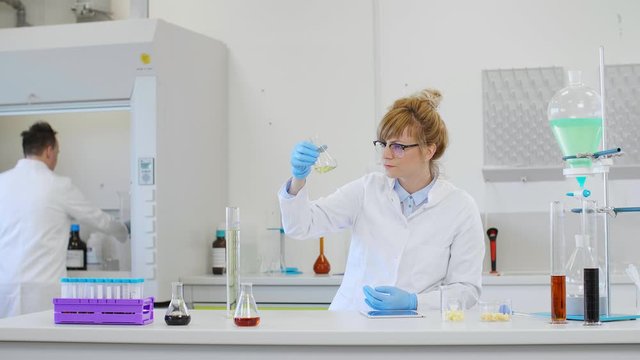 Chemist working with hemp CBD oil and tablet in laboratory