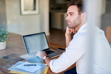 Businessman deep in thought while working at his dining table
