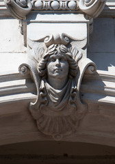 Stone face sculpture on building facade