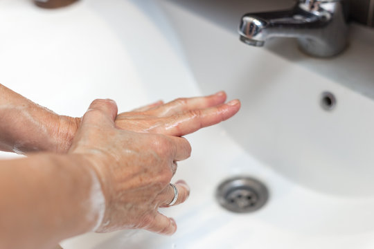 Woman Rubbing Alcohol Based Cleaner On Her Hands