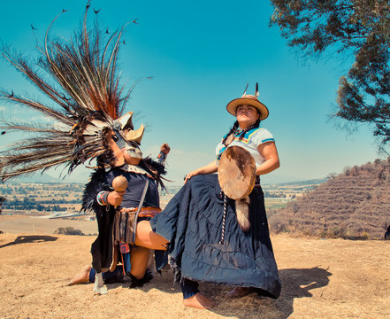 Mexican dancers posing at camera with tufts and pre-Hispanic dress