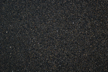 Black sand texture at the sea beach. Abstract background