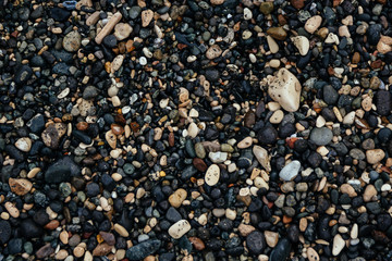 Black and white rocks on black sand texture