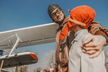 Fototapeta premium Happy dad in aviator hat looking at his son