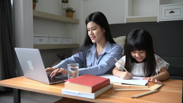 Family Concept. Mother Is Working At Home And Looking After Her Daughter. 4k Resolution.