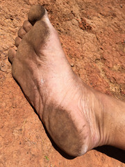 dirty foot on red ground