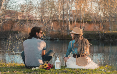 Couple sitting on the grass in front of the river