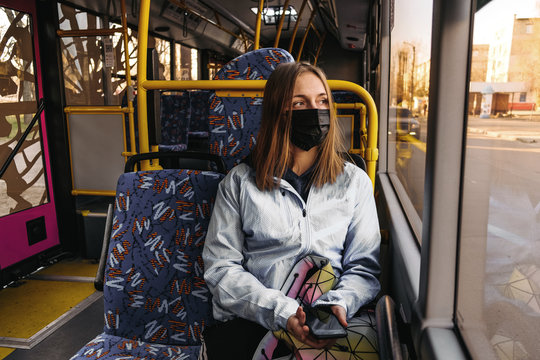 Coronavirus, covid 2019, young woman with respiratory mask traveling in the public transport by bus