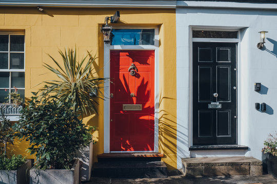 Red Front Door On A Yellow House In London, UK.