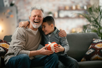 Grandfather giving gift to grandson. 