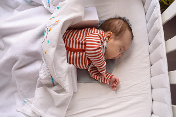Bebé pequeño dormido en cuna