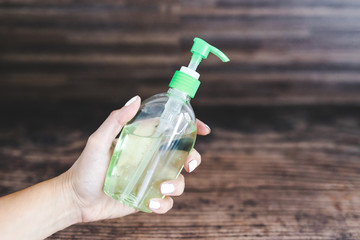 woman's hand holding hand sanitizer bottle