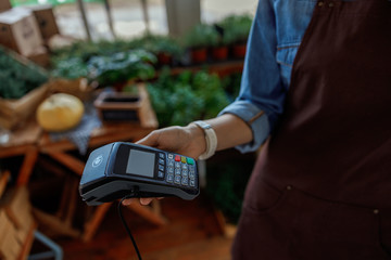 Female holding a payment terminal in her hand