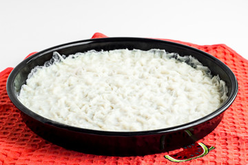 Preparation Traditional Turkish Ramadan Dessert;Gullac is in black,round,metal tray on fabric napkin.
