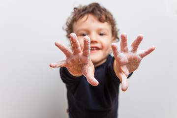 boy, toddler pulls soaped hands forward into the frame. Hygienic procedures, prevention of diseases with viruses and SARS. How to protect yourself from COVID-19. Proper hand washing.
