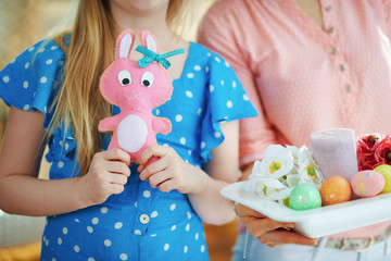 elegant mother and daughter with rabbit toy and easter plate