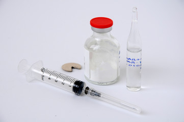medical ampoules and syringe on a white background