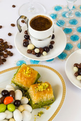 Traditional Turkish Pastry Pistachio Baklava and almond candies on stylish plate with Turkish coffee. Conceptual image of celebrations.