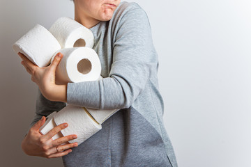 woman eagerly pulls a lot of rolls of toilet paper. Excitement. Studio photo, isolated.