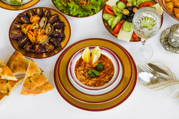 Traditional Ramadan Dinner-Iftar menu designed with elegant dinnerware;soup,dry date fruits,salad,bread and water.