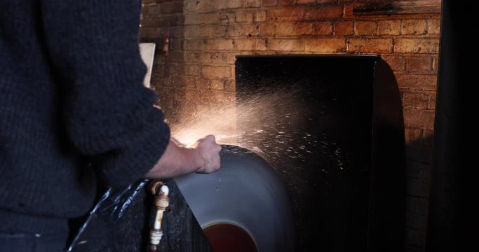 Bladesmith wet grinding a blade