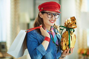 happy stylish woman in glasses with easter egg and shopping bag