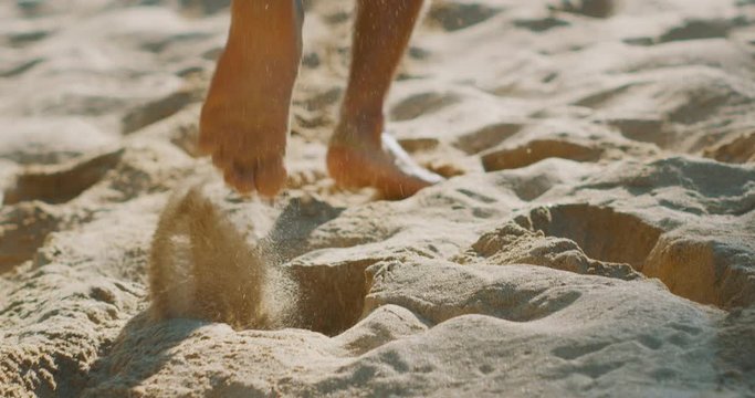 A mans feet running up a sand hill in slow motion