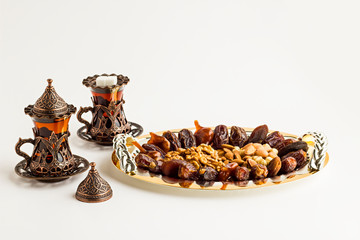 Luxury Dry Date Fruits,walnut,pistachio,hazelnuts and almonds in the stylish,golden tray with tea.Conceptual image of Islamic Tradition Ramadan.