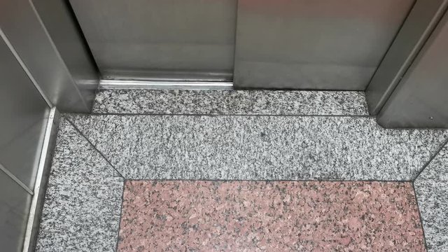 POV. Granite Flooring. The Steel Elevator Door Is Opened. Feet In Brown Sandals, Classic Blue Jeans, Step Out In The Elevator With Vintage Floors.